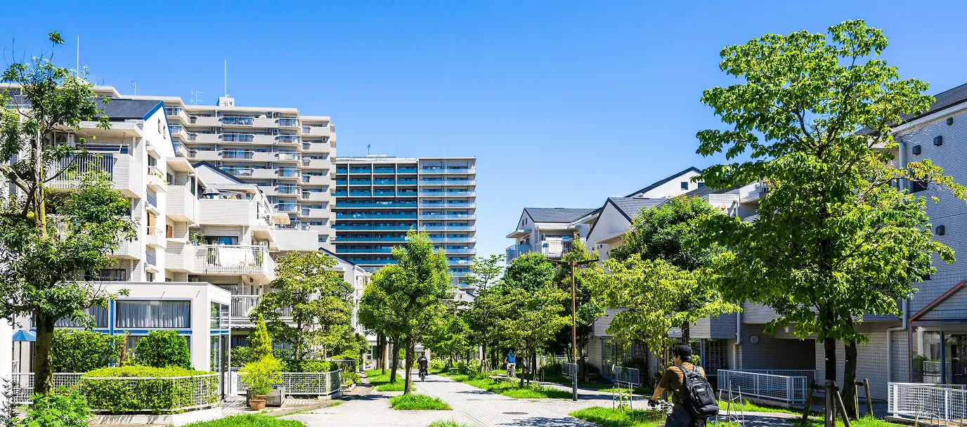 緑豊かな住宅街を歩く人のいる風景