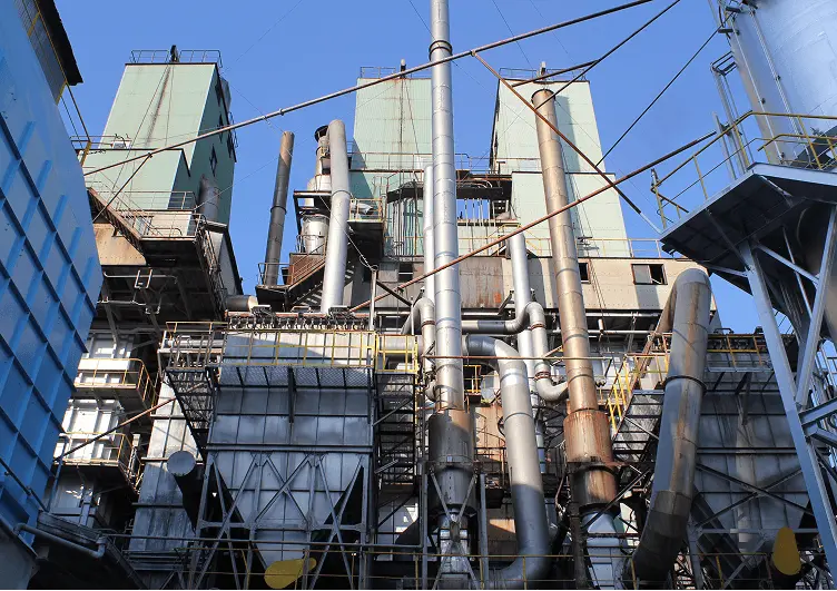 複雑に配管やダクトが組み合わさった大型の工場プラントの外観。高い塔状設備や金属製の配管が並び、産業用設備の稼働を示す構造が見える。