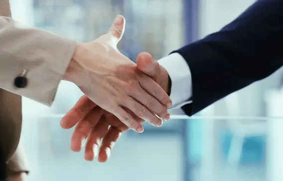 ビジネススーツの人物同士が握手している様子