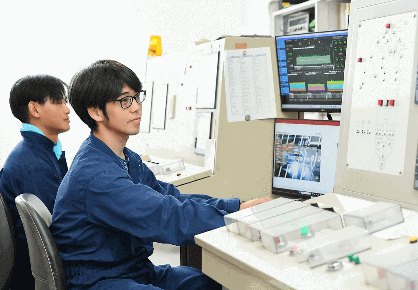 操作室で複数のモニターを前に作業員が設備の状態を監視している様子
